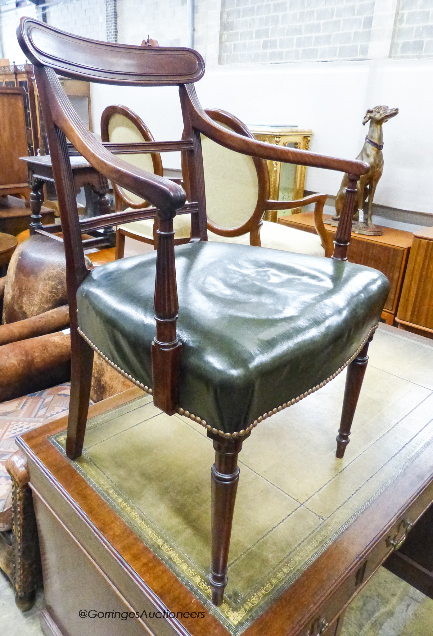 An Edwardian mahogany pedestal desk, length 138cm, depth 75cm, height 74cm together with a George III mahogany elbow chair